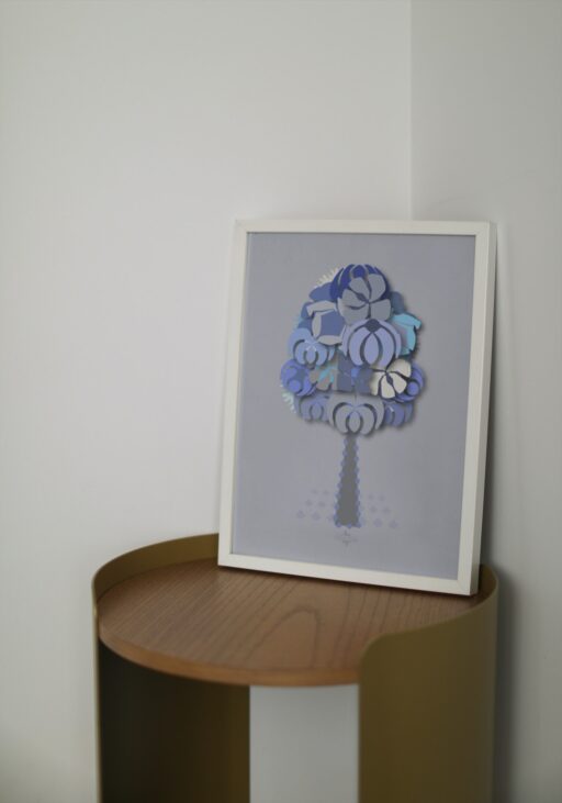 blue geometrical tree small poster in a white frame on a wooden table