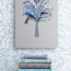 blue palm tree wall decor above stack-of-books-on-wooden-stool