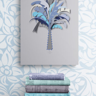 blue palm tree wall decor above stack-of-books-on-wooden-stool