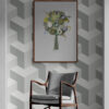 green round tree framed wall art against grey geometrical wallpaper and retro armchair