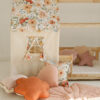 Flower Power bed canopy in pink and peach shades in a cosy kids bedroom with cushions