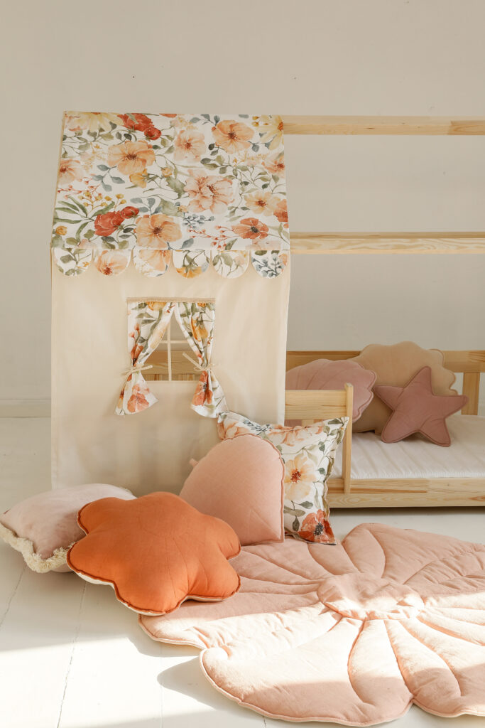Flower Power bed canopy in pink and peach shades in a cosy kids bedroom with cushions