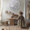Grey Moon wall decor in a neutral and organic kids interior with little girl