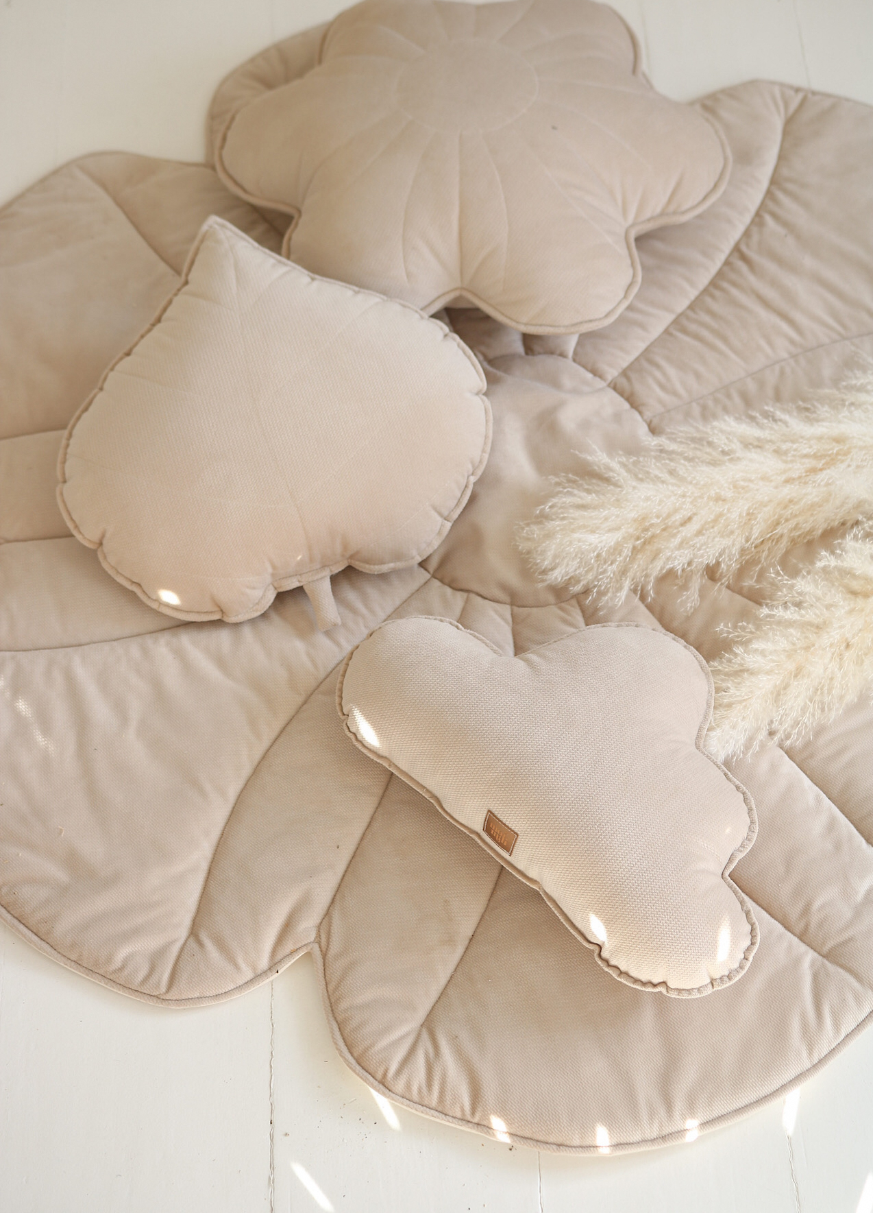 Soft, delicate and subtle pillow and matt arrangment - Beige velvet flower pillow, vloud pillow and leaf pillow on a floral floor mat