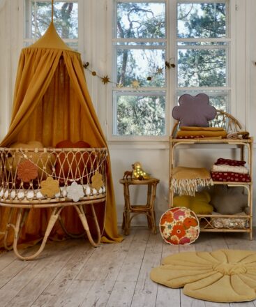 Light nursery in brown - rattan Moses basket with brown canopy over it and flower floor yellow mat