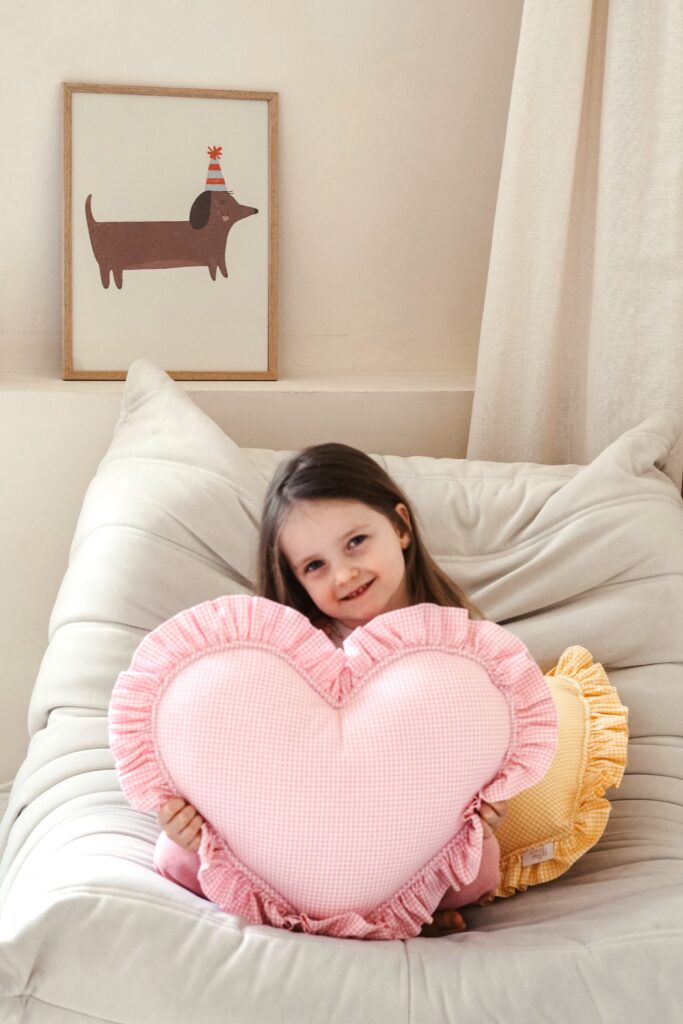 girl with pink checked frilled heart pillow