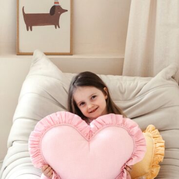 girl with pink checked frilled heart pillow