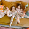 comfortable and solid sun pillow collections in blue white orange and circus round pillows with girls laughing on the couch