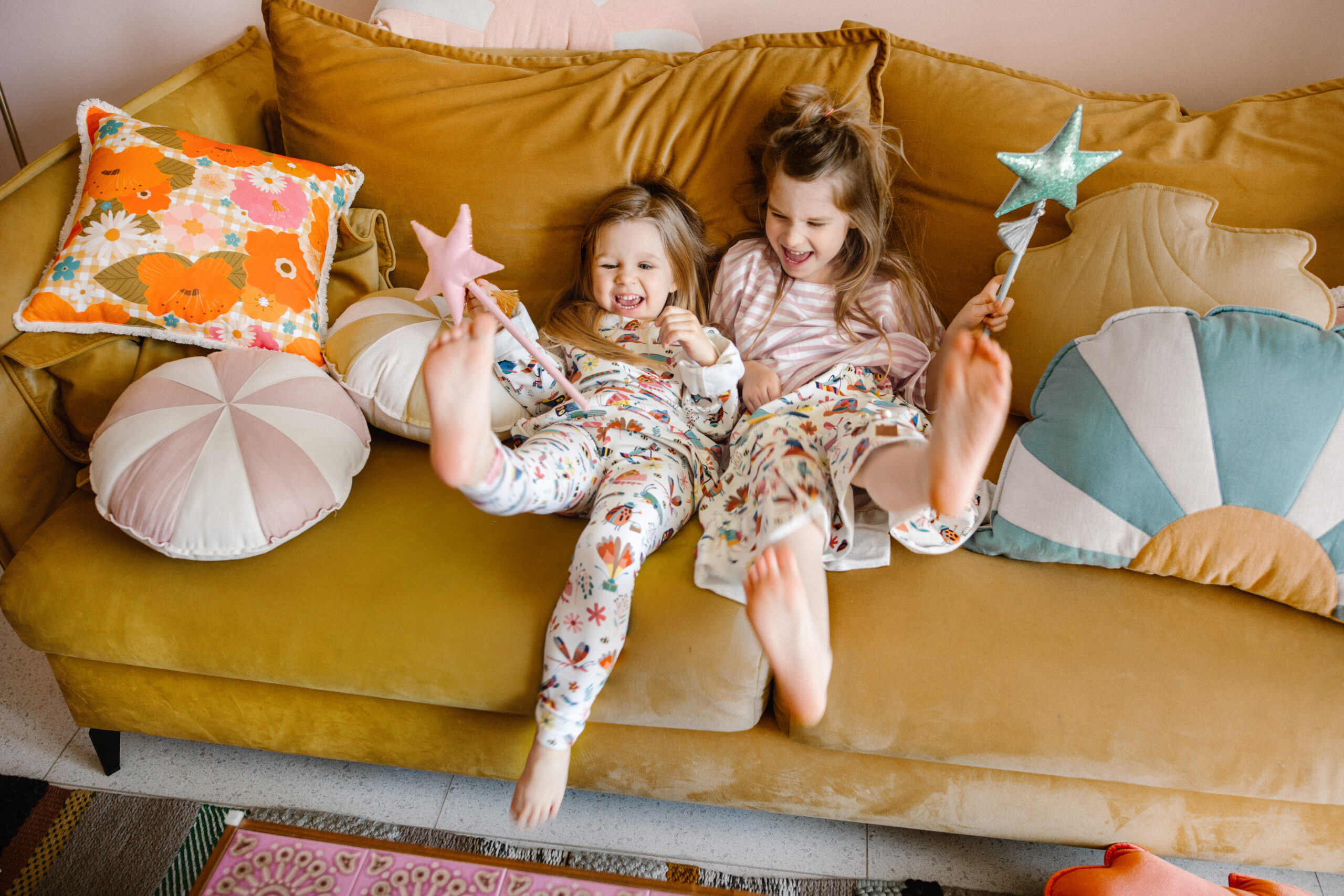 comfortable and solid sun pillow collections in blue white orange and circus round pillows with girls laughing on the couch