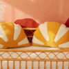 comfortable and solid sun pillow in white orange and on a wicker chair