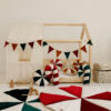 raw cotton bed canopy over house bed with colourful circus mats and pillows