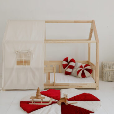 raw cotton bed canopy over house bed with colourful circus mats and pillows